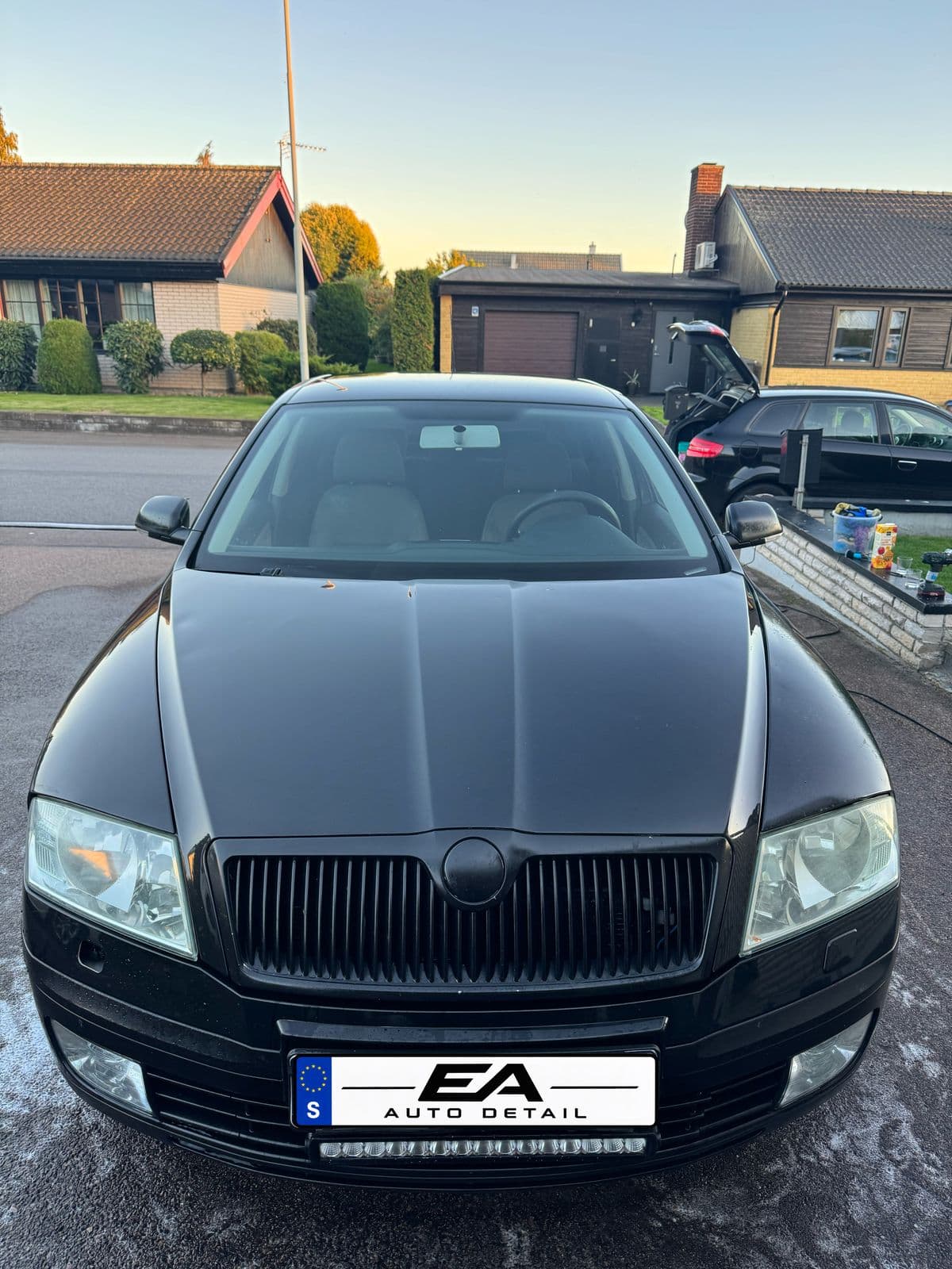 Efter: samma bil framifrån, nytvättad och blank.